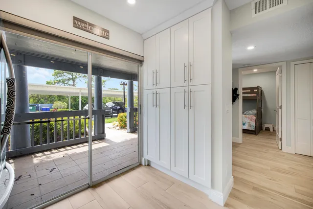 a room with stainless steel appliances kitchen island granite countertop a table chairs in it and wooden floors