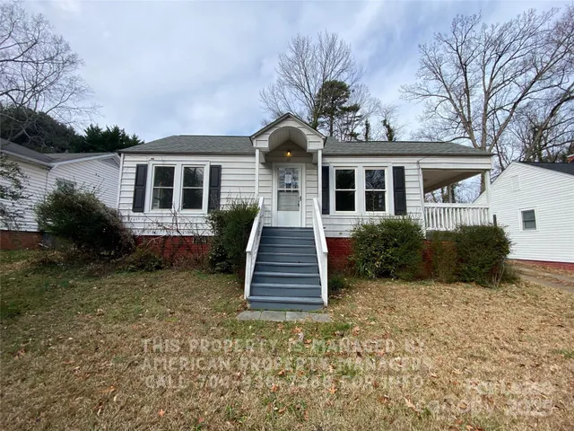 a front view of a house with a yard and outdoor seating