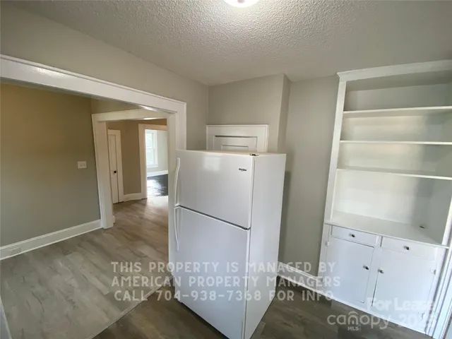 a view of kitchen with furniture and refrigerator
