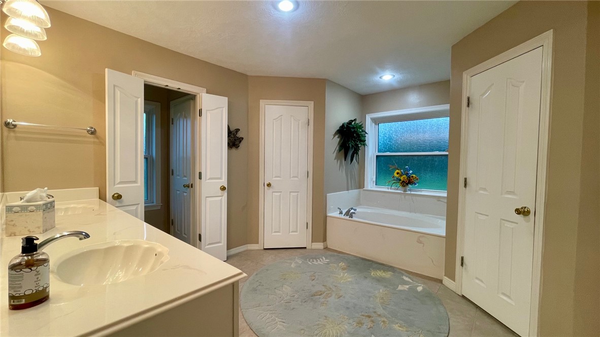 10432 Sammys Road Bremond, TX 76629 - Photo 17 of 47 a bathroom with a tub sink and mirror