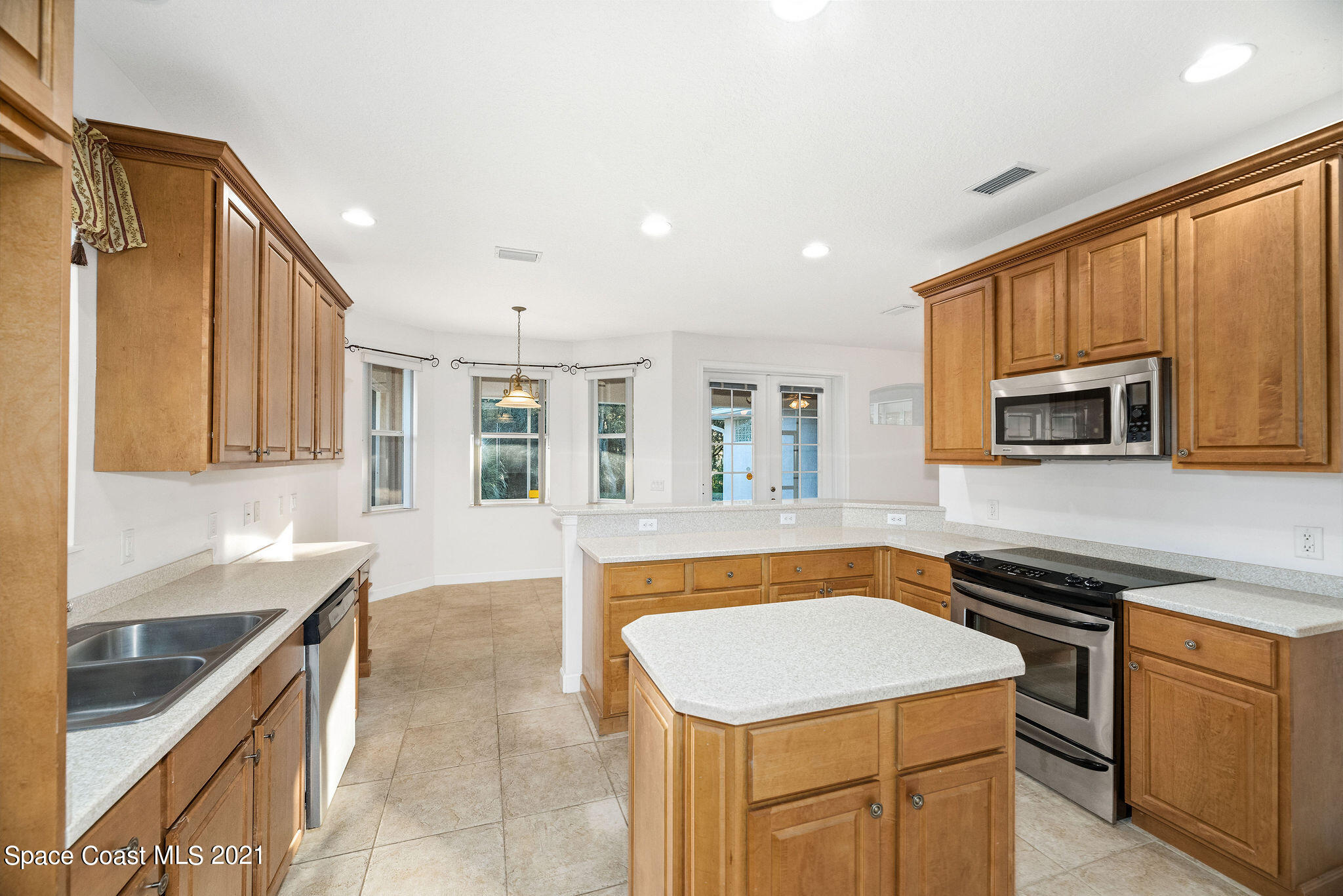 3748 Turtle Mound Road Melbourne, FL 32934 - Photo 12 of 68 a kitchen with stainless steel appliances granite countertop a sink and dishwasher a stove top oven with wooden floor