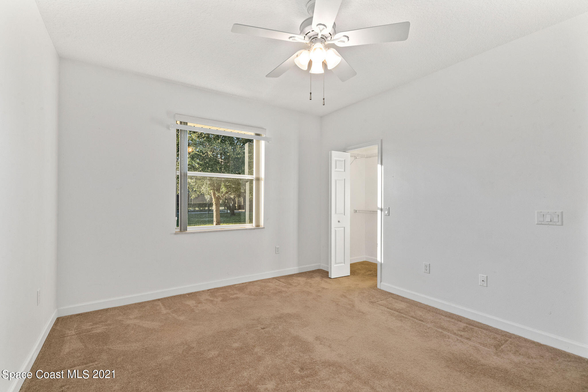 3748 Turtle Mound Road Melbourne, FL 32934 - Photo 22 of 68 an empty room with chandelier fan and windows