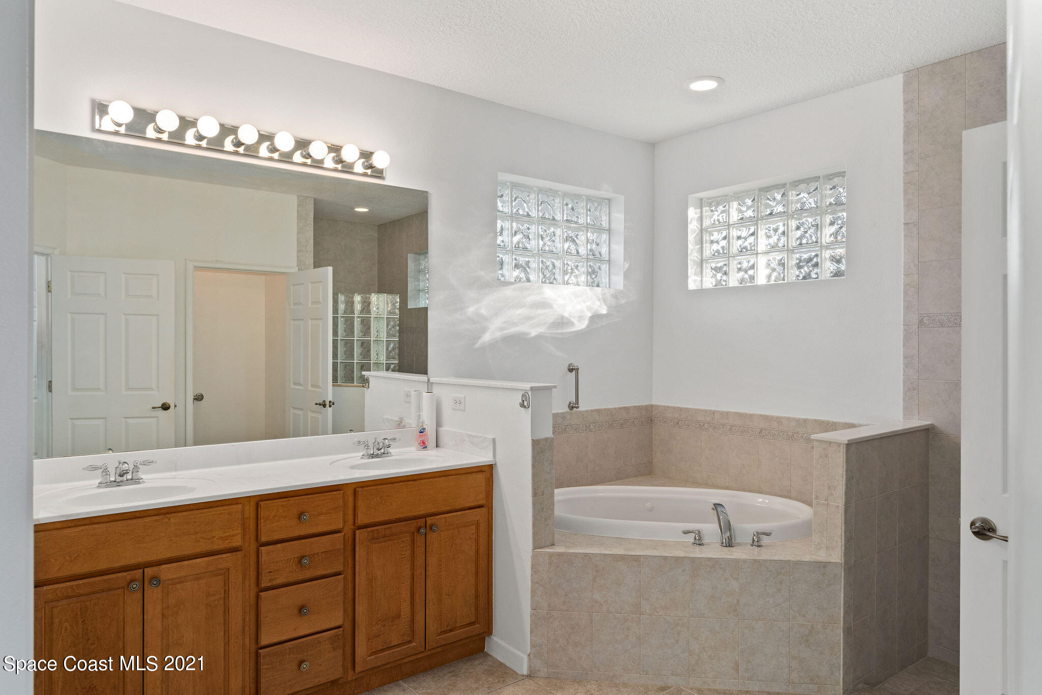 3748 Turtle Mound Road Melbourne, FL 32934 - Photo 26 of 68 a spacious bathroom with a tub a sink and mirror