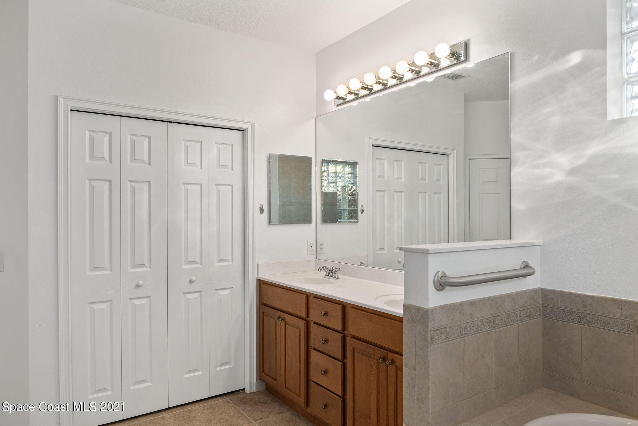 3748 Turtle Mound Road Melbourne, FL 32934 - Photo 28 of 68 a bathroom with a sink vanity and mirror
