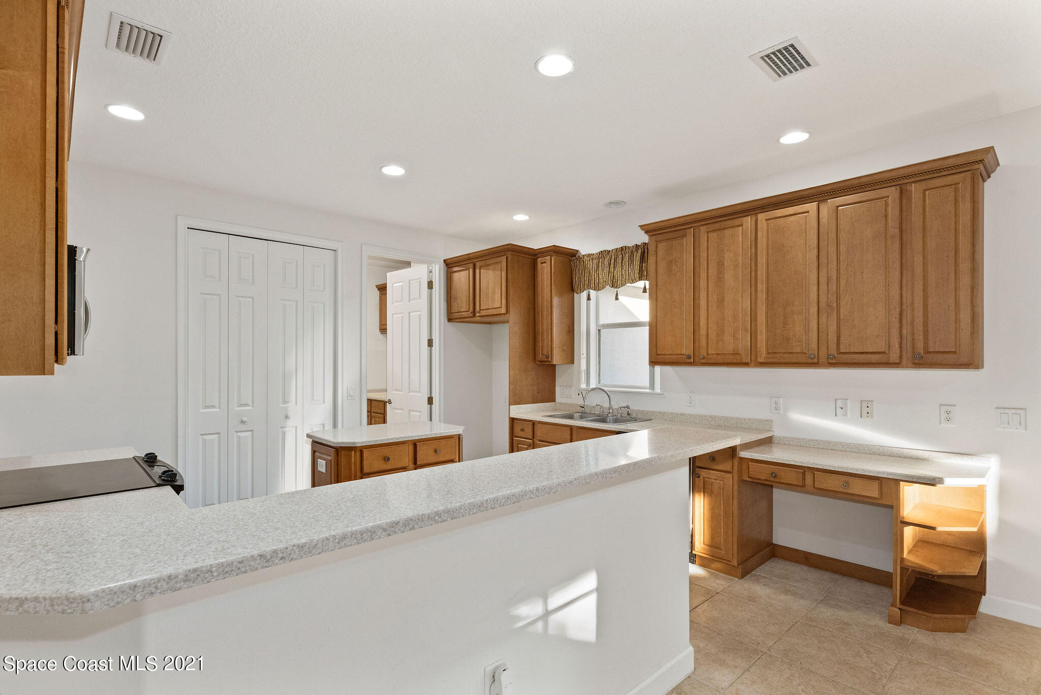 3748 Turtle Mound Road Melbourne, FL 32934 - Photo 9 of 68 a kitchen with kitchen island a sink and wooden cabinets