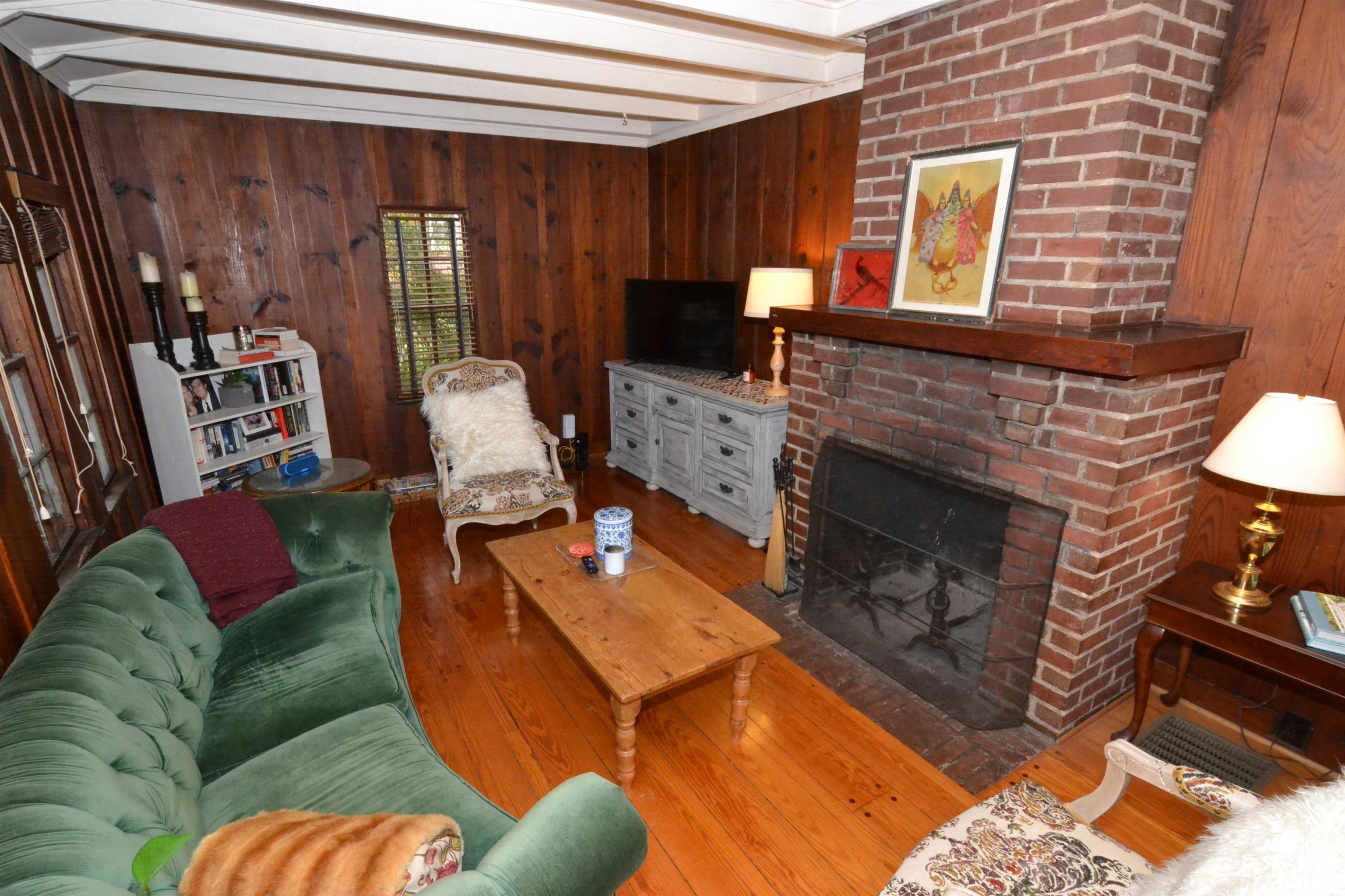 1004 Brooks Avenue Raleigh, NC 27607 - Photo 6 of 17 a living room with furniture a flat screen tv and a fireplace