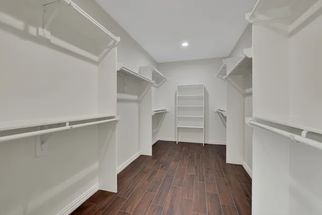 a view of walk in closet with wooden floor