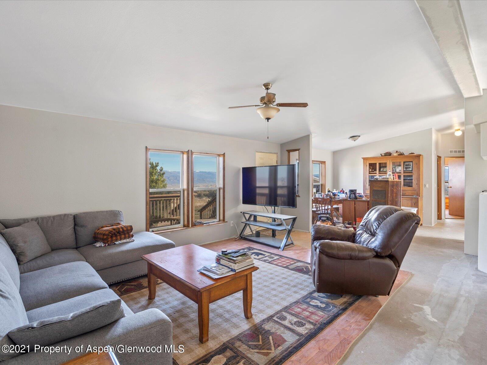 4300 Grass Mesa Road Rifle, CO 81650 - Photo 11 of 45 a living room with furniture a flat screen tv and a large window