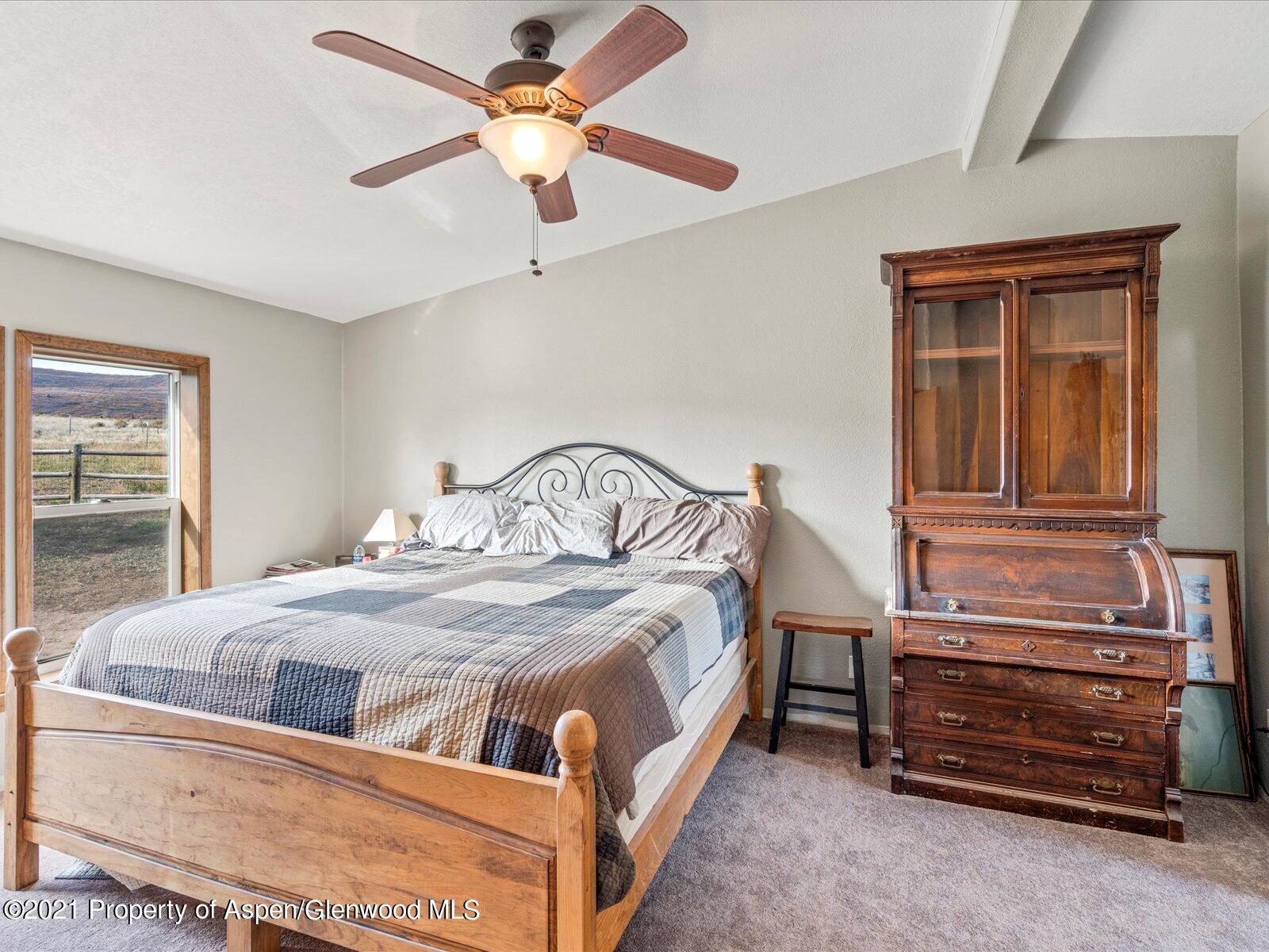 4300 Grass Mesa Road Rifle, CO 81650 - Photo 19 of 45 a bedroom with a bed and a chandelier