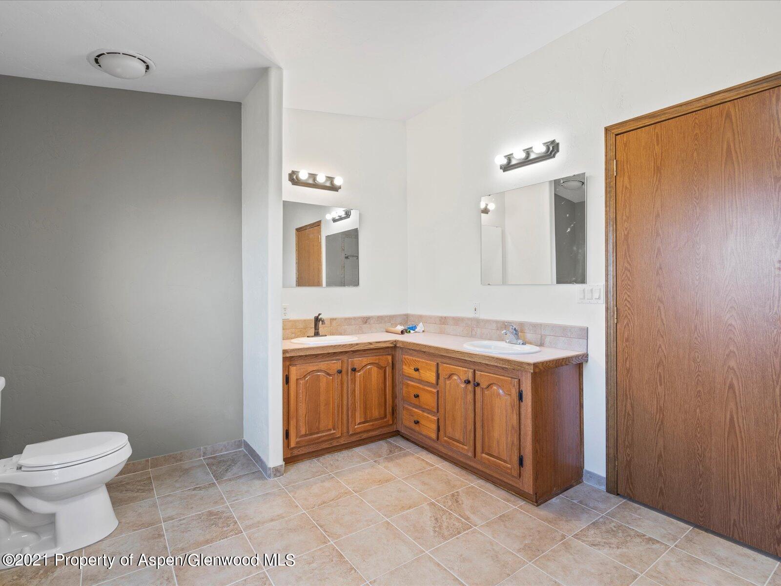 4300 Grass Mesa Road Rifle, CO 81650 - Photo 24 of 45 a spacious bathroom with a granite countertop sink and a mirror