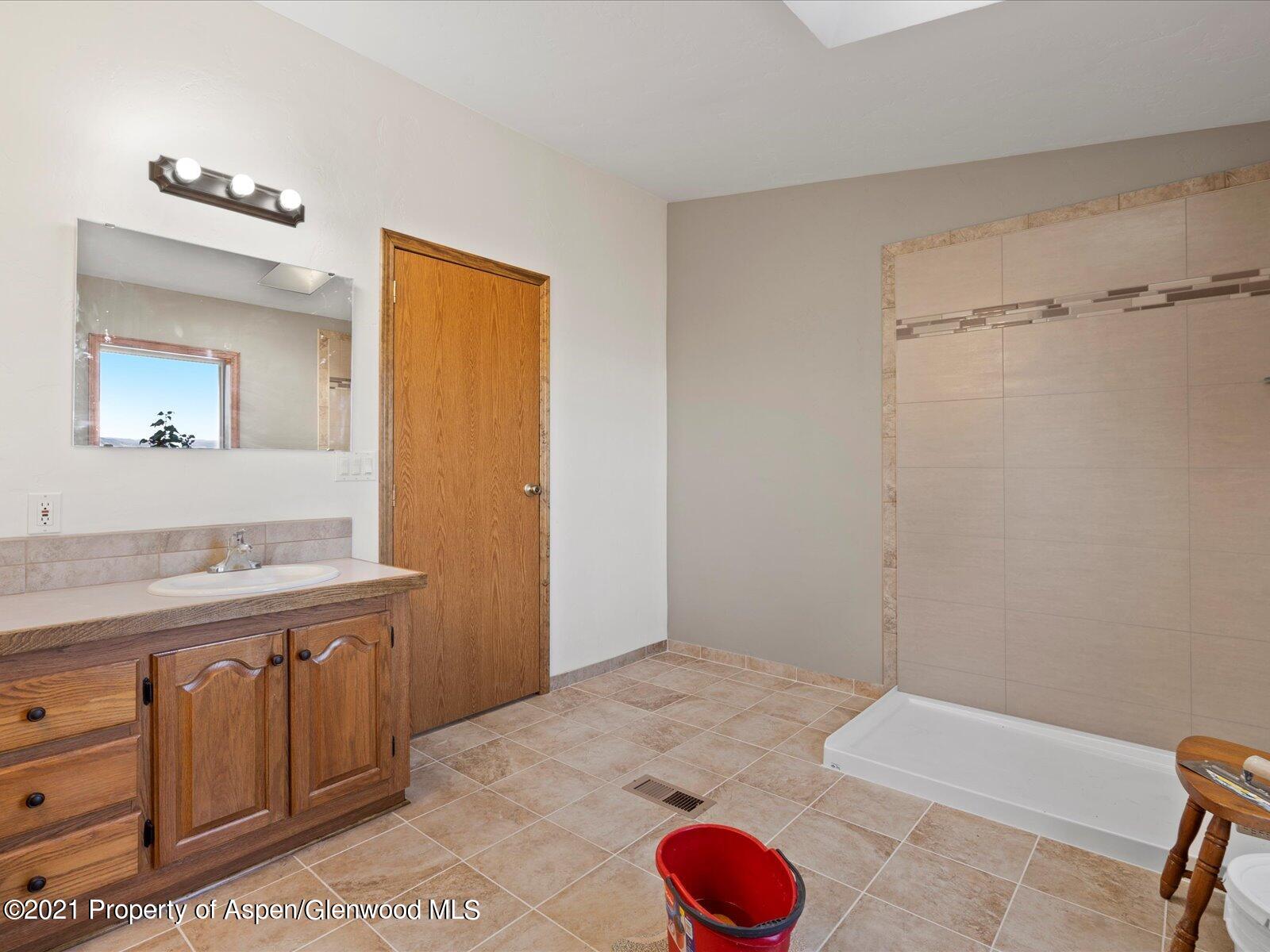 4300 Grass Mesa Road Rifle, CO 81650 - Photo 25 of 45 a bathroom with a tub sink and mirror