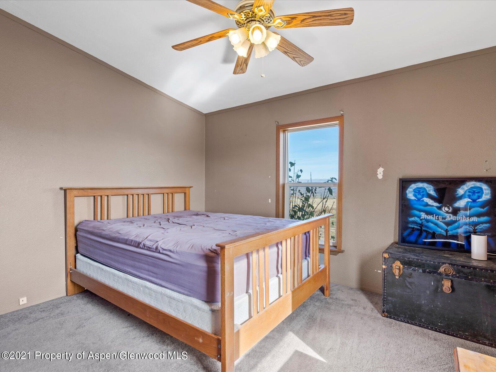 4300 Grass Mesa Road Rifle, CO 81650 - Photo 29 of 45 a bedroom with a bed and a chandelier