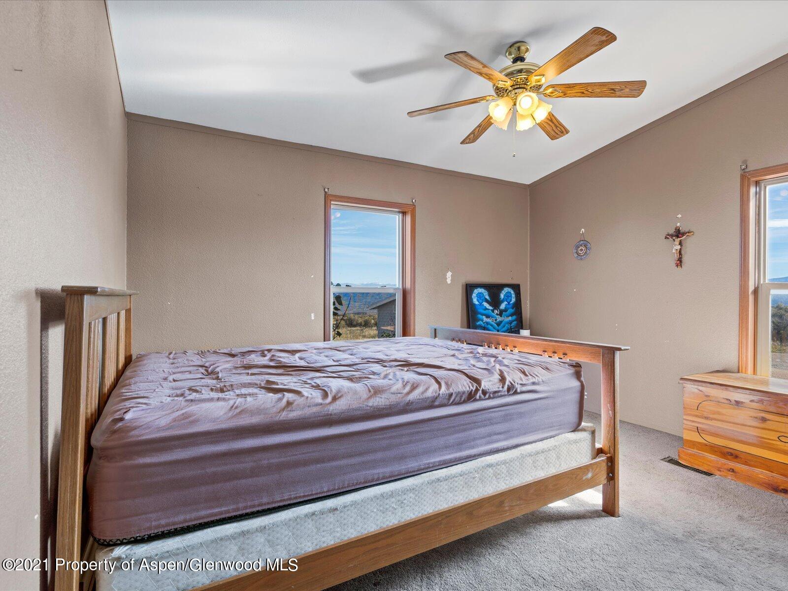 4300 Grass Mesa Road Rifle, CO 81650 - Photo 30 of 45 a bedroom with a bed and a chandelier