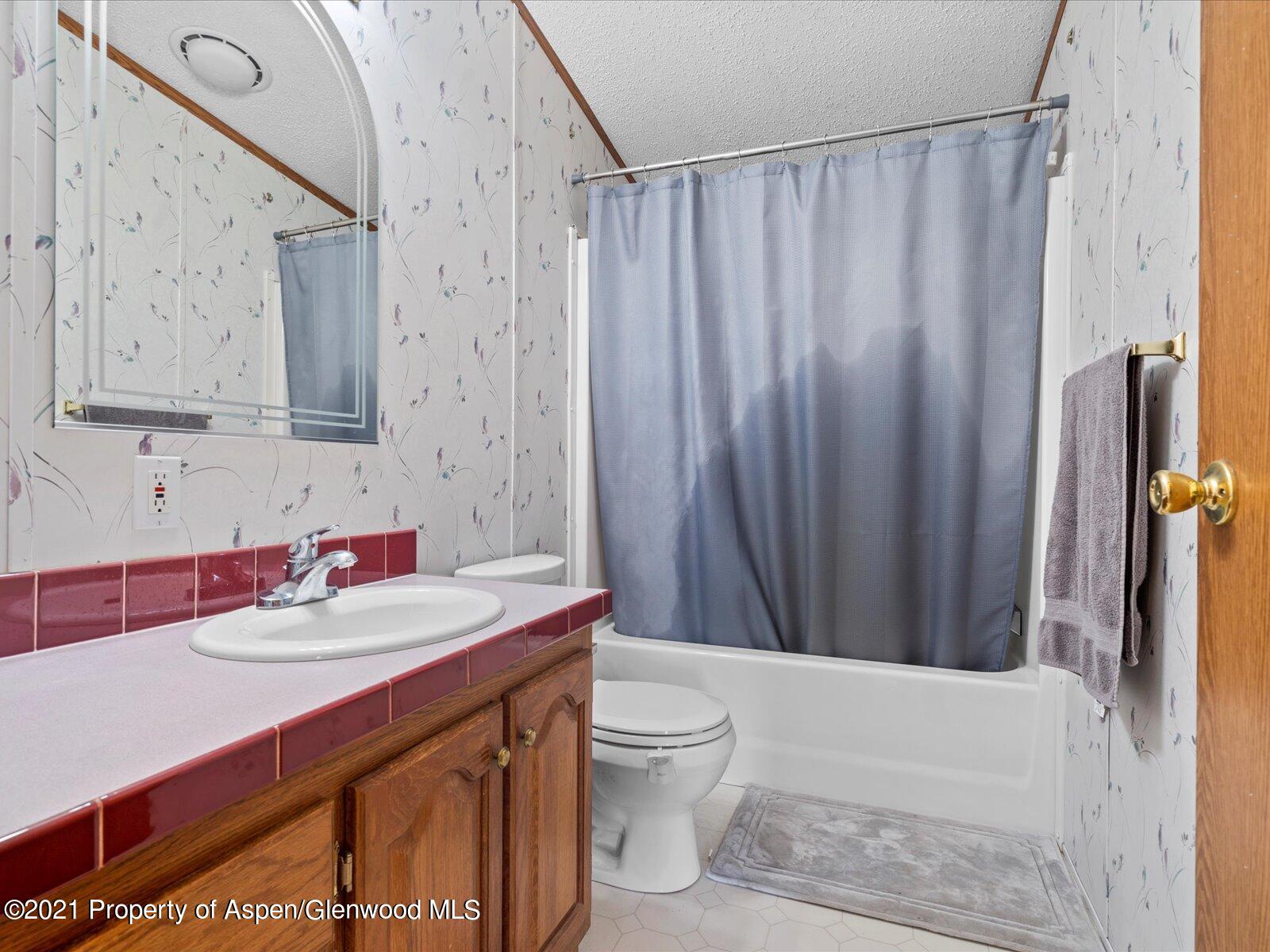 4300 Grass Mesa Road Rifle, CO 81650 - Photo 31 of 45 a bathroom with a sink a toilet and shower curtain