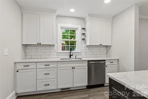 a kitchen with white cabinets and sink