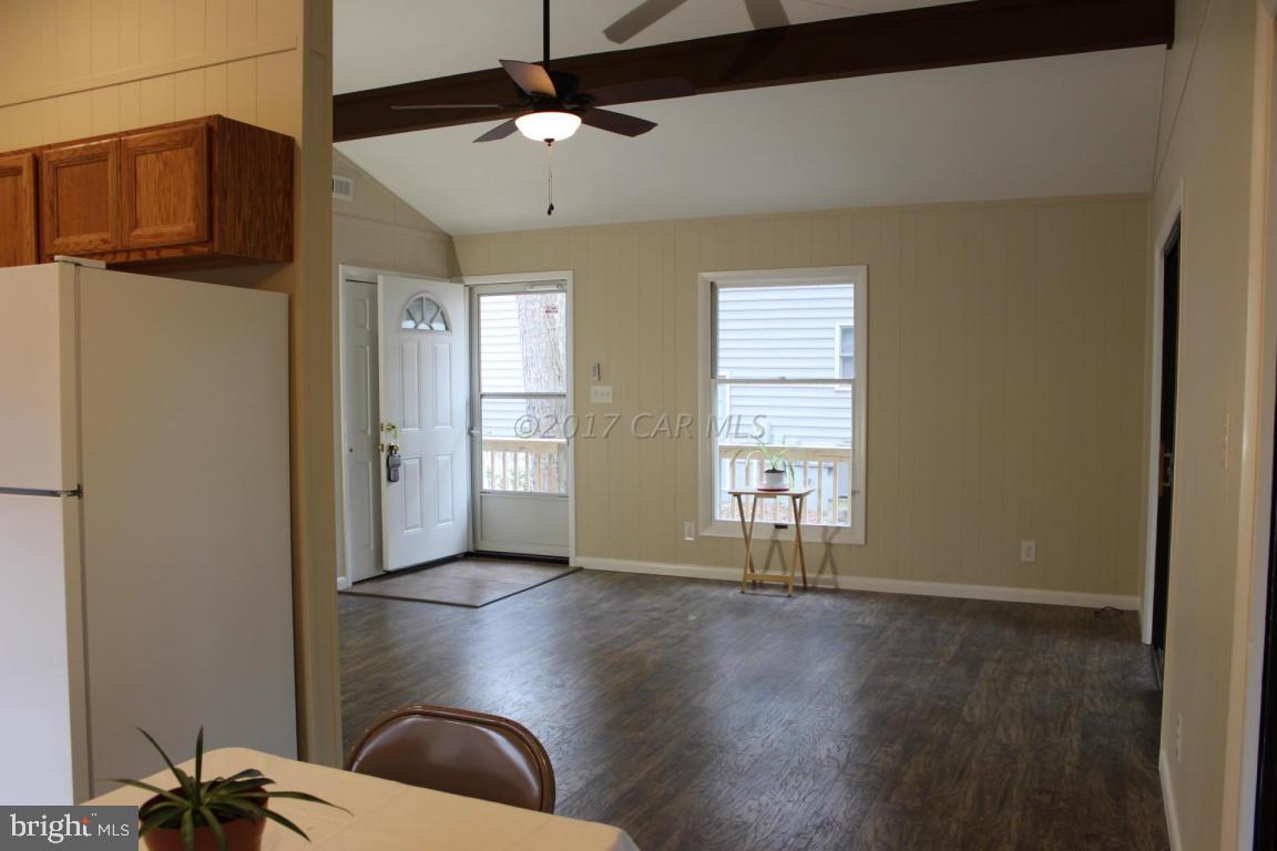 129 Windjammer Road Ocean Pines, MD 21811 - Photo 4 of 36 a view of an empty room with a window and wooden floor