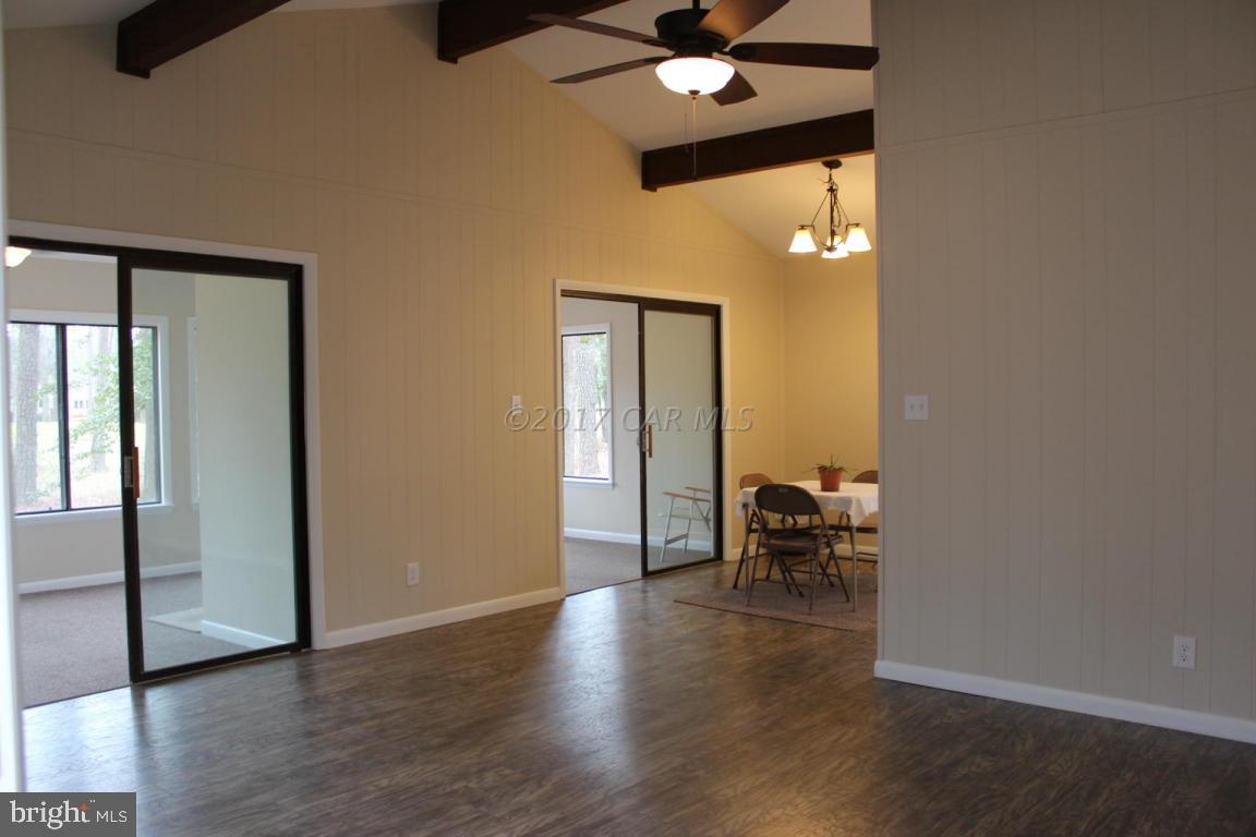 129 Windjammer Road Ocean Pines, MD 21811 - Photo 5 of 36 an empty room with wooden floor and a chandelier fan