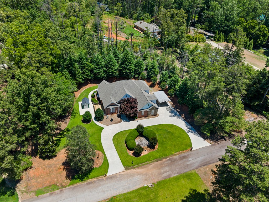 135 Sunset Bay Boulevard Seneca, SC 29672 - Photo 48 of 50 A private, tree-lined property features a circular driveway and well-maintained landscaping.
