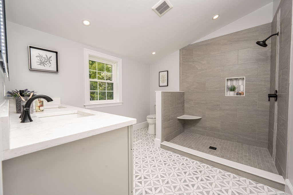 61 Sheffield Road Melrose, MA 02176 - Photo 15 of 21 a bathroom with a shower sink and mirror