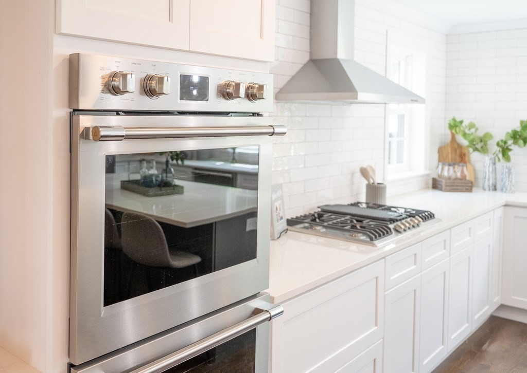 61 Sheffield Road Melrose, MA 02176 - Photo 7 of 21 a stove top oven sitting inside of a kitchen and white cabinets