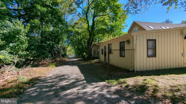 a front view of a house with a yard covered with trees