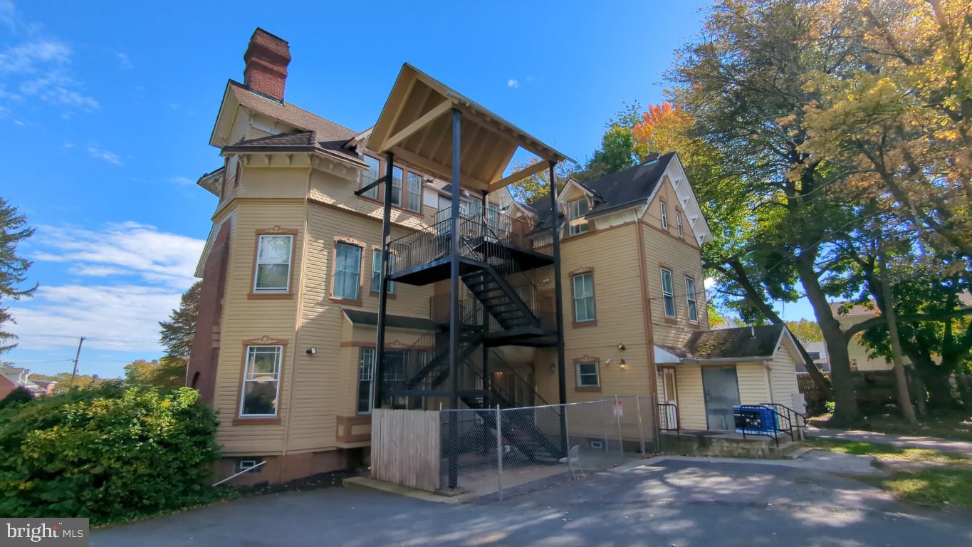 900 Main Street Brookhaven, PA 19015 - Photo 4 of 42 a view of a white house with large windows and a small yard
