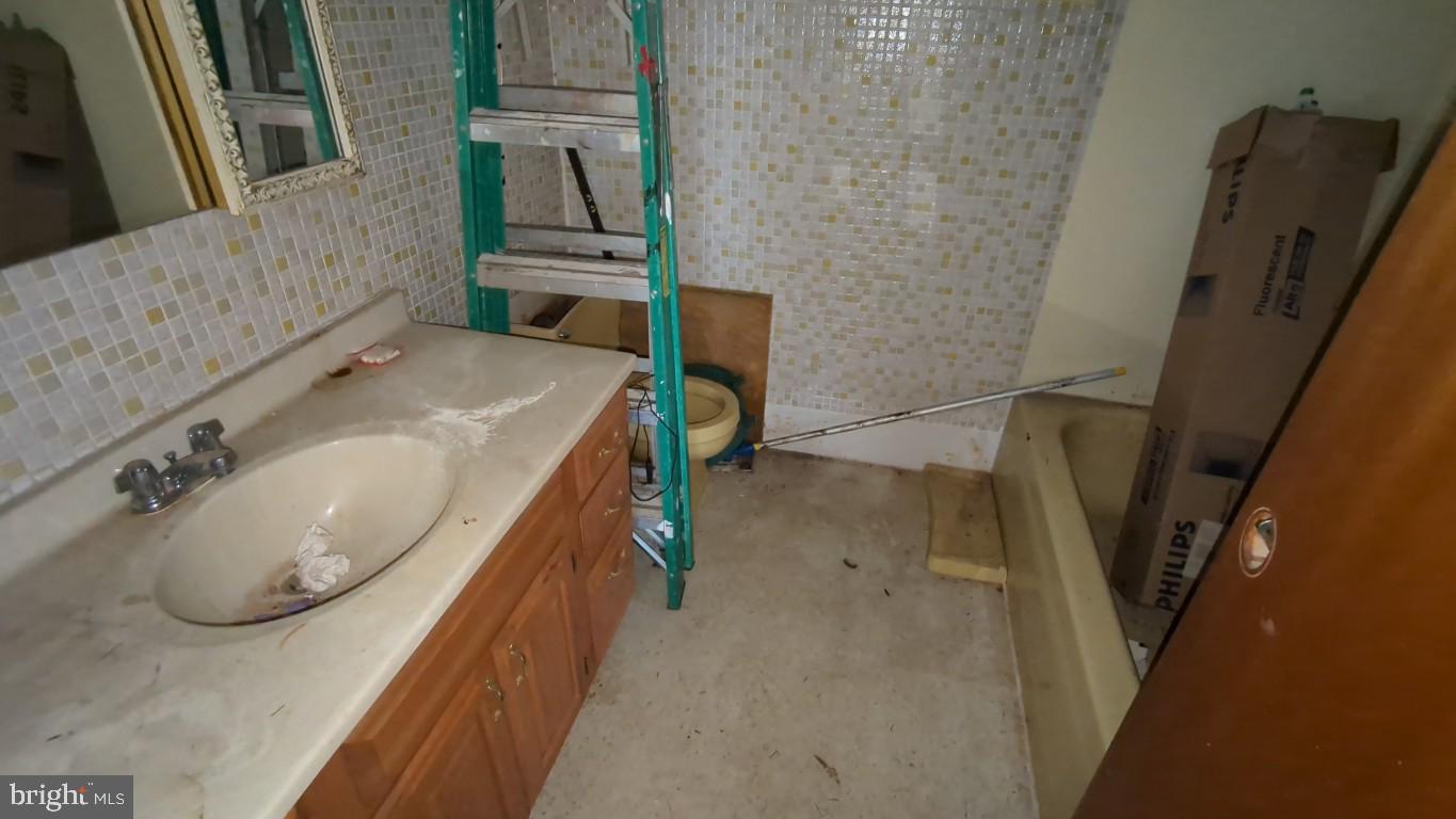 900 Main Street Brookhaven, PA 19015 - Photo 42 of 42 a bathroom with a granite countertop sink and a mirror