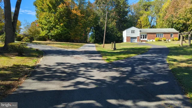 a view of swimming pool with lawn chairs and plants