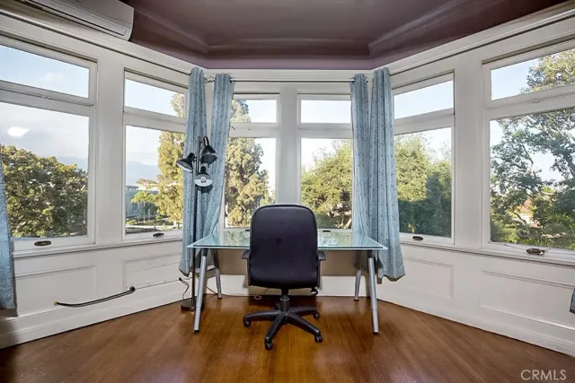 a view of a workspace with furniture and a window