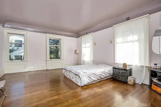 a spacious bedroom with a bed a table and a large window