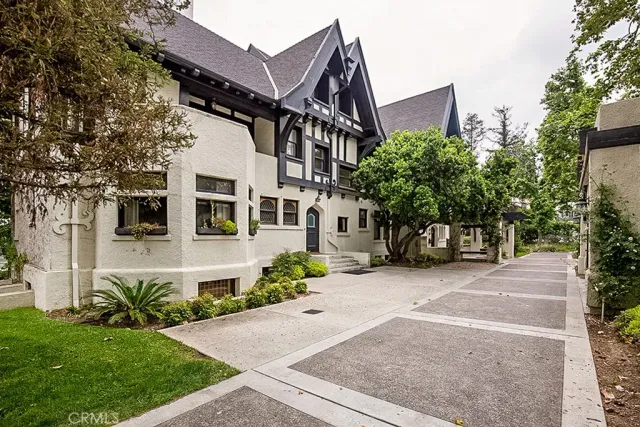 a front view of a house with a yard and potted plants