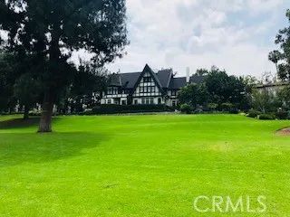 a view of a big house with a big yard and large trees