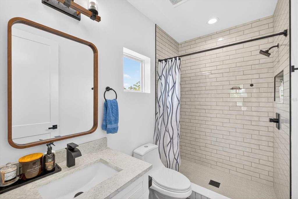 7301 South Elliott Street Tampa, FL 33616 - Photo 31 of 54 a bathroom with a sink a toilet and shower