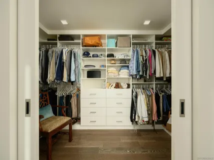 a view of walk in closet with clothes and shoes