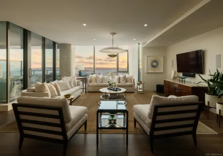 a living room with furniture a flat screen tv and a floor to ceiling window