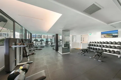 a room with gym equipment and large mirror