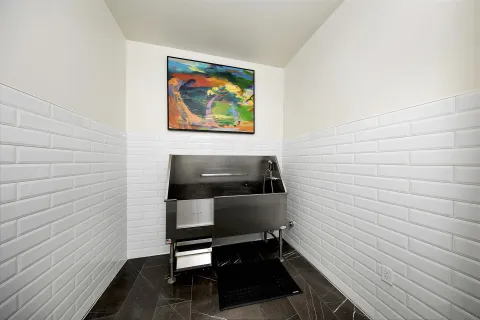 a hallway with a bench and paintings on the wall