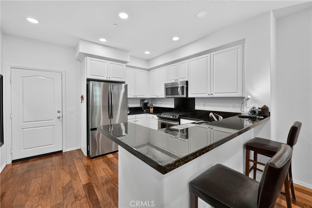 849 The Promenade, Unit D Azusa, CA 91702 - Photo 15 of 37 a kitchen with a refrigerator a stove a sink and a cabinets