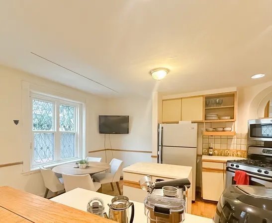 a room with furniture a flat screen tv and a refrigerator