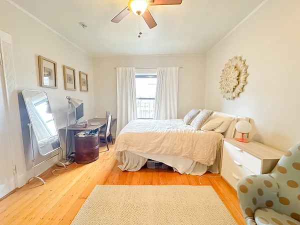 a bed sitting in a bedroom next to a window with pc on the table