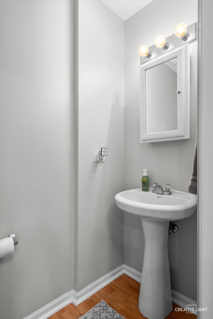 616 Springbrook Trail North Oswego, IL 60543 - Photo 5 of 18 a bathroom with a sink a mirror and wooden floor