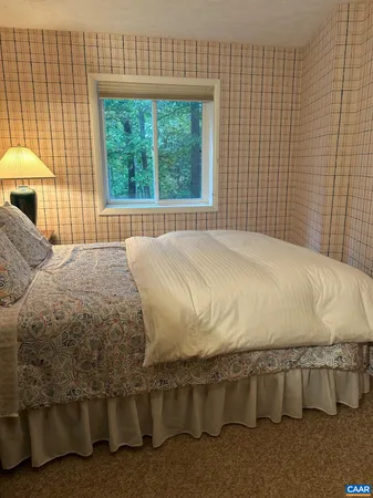 a bed sitting in a bedroom next to a window
