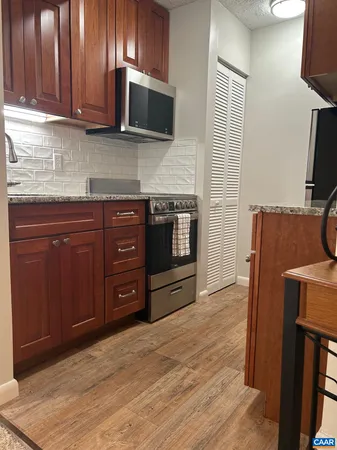 a kitchen with stainless steel appliances granite countertop a stove microwave and sink