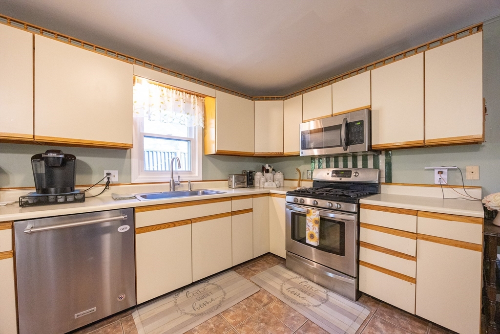 11 Edgeworth Street Billerica, MA 01821 - Photo 14 of 40 a kitchen with stainless steel appliances granite countertop a sink a stove and cabinets