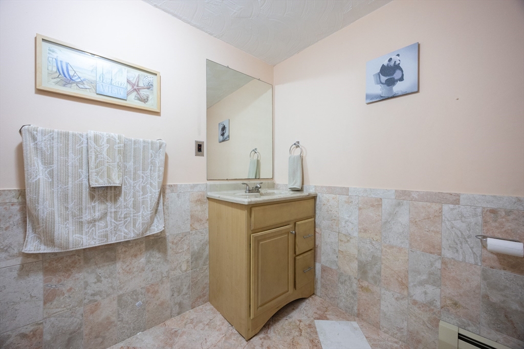 11 Edgeworth Street Billerica, MA 01821 - Photo 32 of 40 a bathroom with a granite countertop sink a mirror and vanity