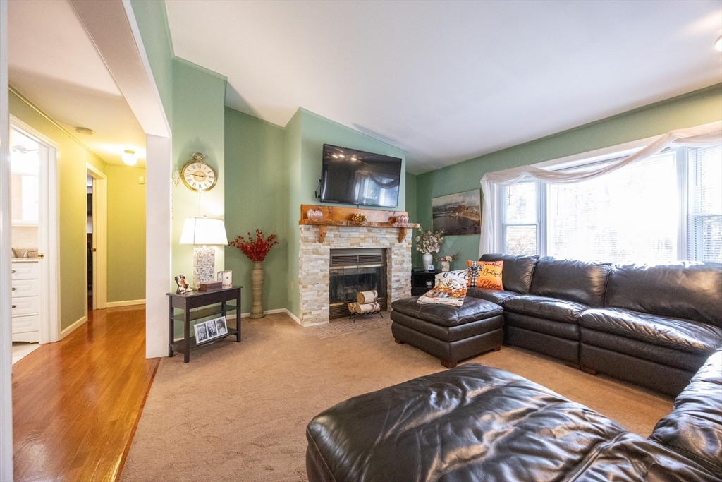 11 Edgeworth Street Billerica, MA 01821 - Photo 9 of 40 a living room with furniture a fireplace and a flat screen tv