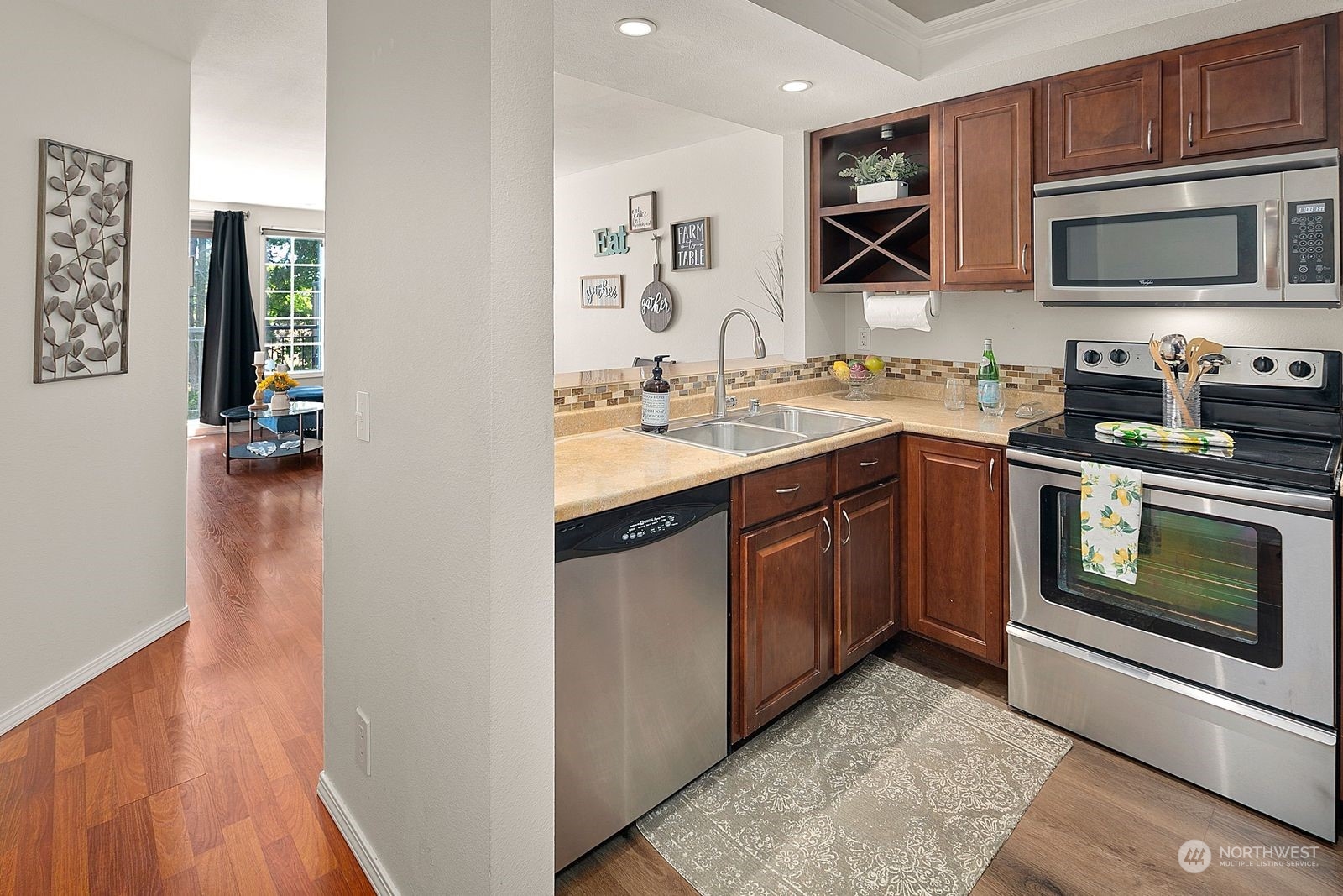 8512 242nd Street Southwest, Unit 4 Edmonds, WA 98026 - Photo 4 of 24 a kitchen with stainless steel appliances granite countertop a stove top oven a sink dishwasher and a microwave oven with wooden floor