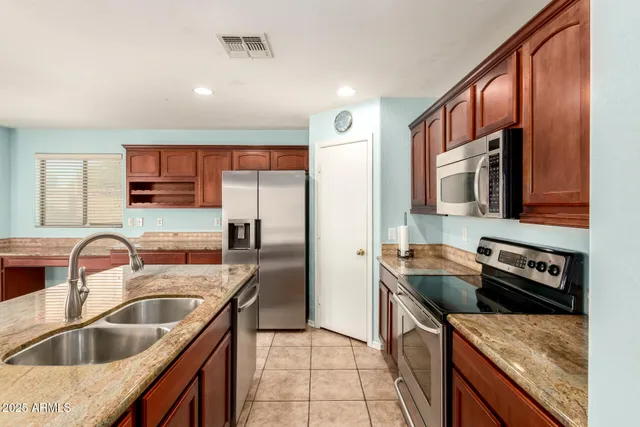 a kitchen with a sink stove top oven and refrigerator