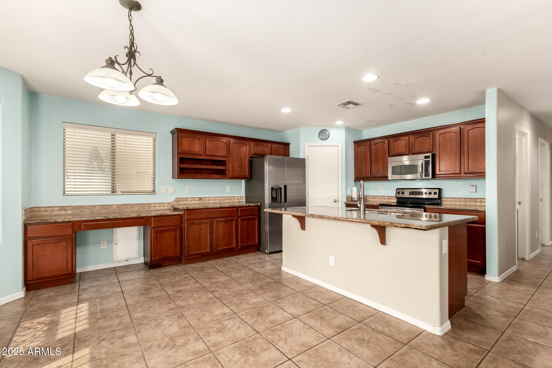 4403 West Maldonado Road Laveen, AZ 85339 - Photo 14 of 37 a kitchen with stainless steel appliances granite countertop a stove top oven a sink dishwasher a dining table and chairs