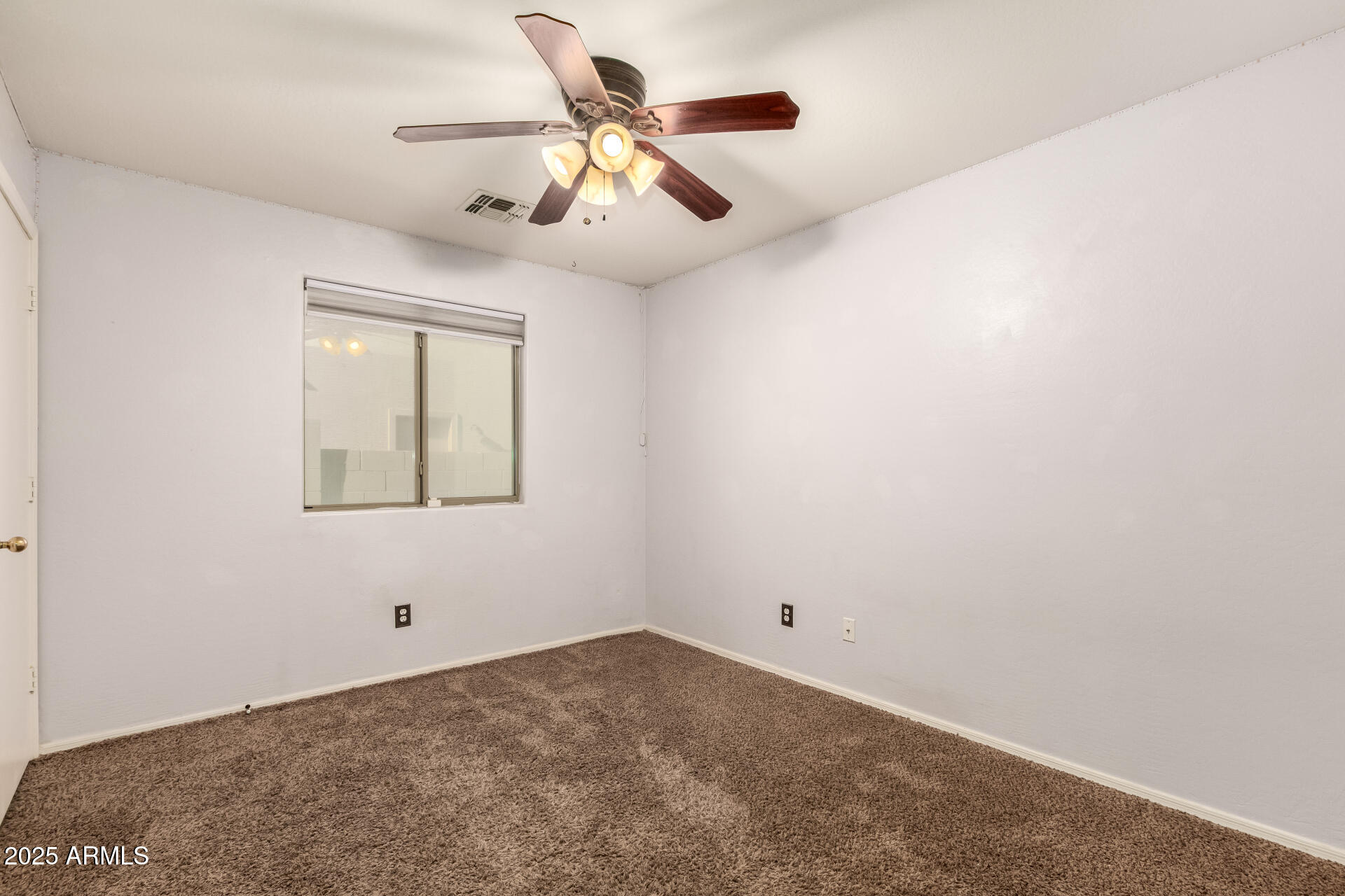 4403 West Maldonado Road Laveen, AZ 85339 - Photo 16 of 37 an empty room with a window and a ceiling fan